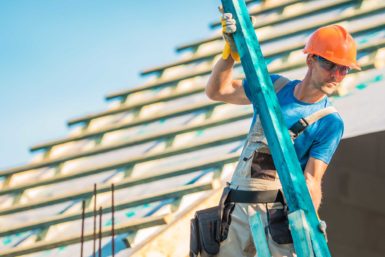 Roofer holding wooden beam during an install