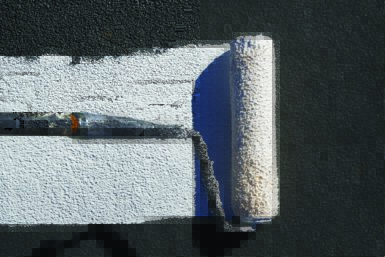 Roller applying a roof coating