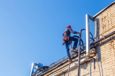 View of a worker climbing ladder to roof