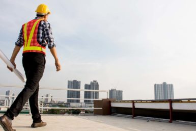 View of roof inspector on commercial roof