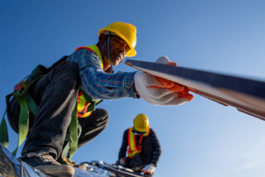 Roofer installing a roofing material