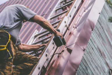 Roofer installing a metal roof
