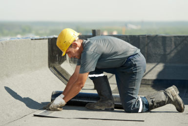 Roofing professional installing a flat roof system