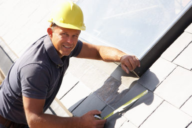 Roofer measuring roofing materials